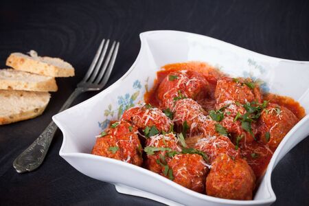 Meatballs in tomato sauce seasoned with parmesan cheese and parsley.の写真素材