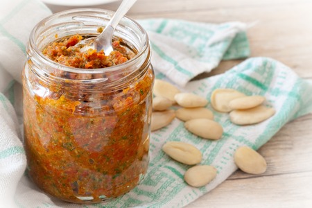Closeup of jar with dried tomatoes pesto. This particular pesto is prepared by an Italian traditional recipe with dried tomatoes in olive oil, almonds, basil, parmesan cheese and olive oil.の写真素材