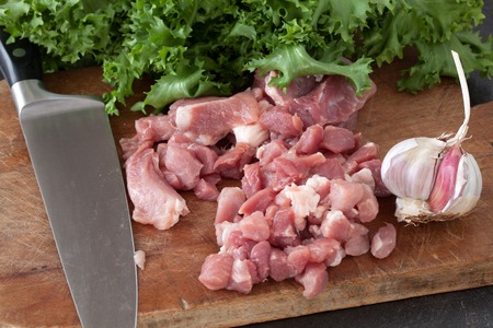 Chopped pork meat on wood kitchen board. with lettuce and garlic.の写真素材