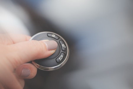 Women finger on car remote key, intentional blurred background with copy space.の写真素材
