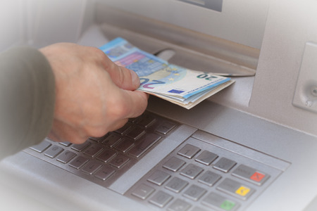 Man hand getting 20 euro banknotes at ATM machine in the bank.の写真素材