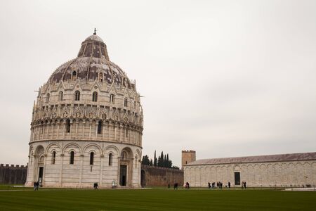 PISA, ITALY - JANUARY 23, 2016: The baptistery in Campo dei Miracoli, during a cold day of winter, with many tourists visiting.のeditorial素材