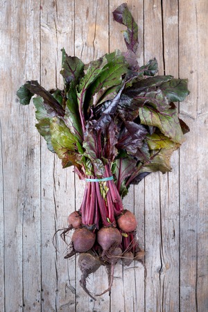 Bunch of raw beetroots just picked from the garden, overhead shot on wood background.