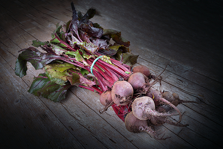 Fresh red turnips, photographed on wood background with dark vignette effect.の写真素材