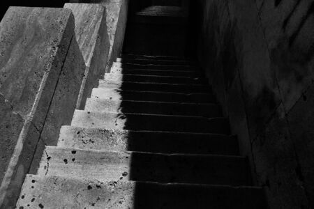 Old stone stairs going down over creepy underground, grunge, black and white shot.の写真素材