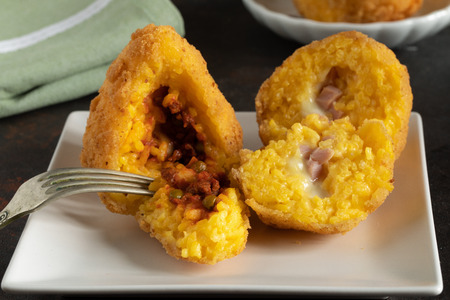 Arancini detail, traditional Italian food, mostly Sicilian, one stuffed with meat and peas ragu and...
