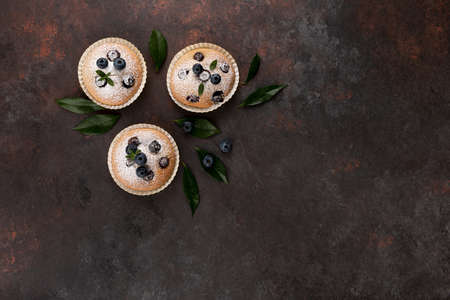 Blueberry muffins top view brown flat lay wooden background with copy spaceの写真素材