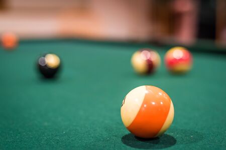 A closup of several billiard balls, with the background balls out of focus