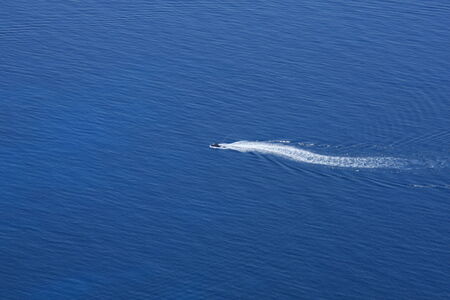 Ski-jet trail on the blue water of the Ionian seaの写真素材