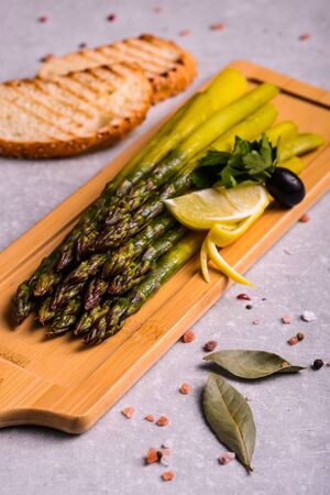 tasty asparagus on a wooden stand with lemonの写真素材