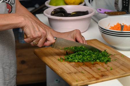 woman cutting parsley on a cutting board in the kitchen 5の写真素材