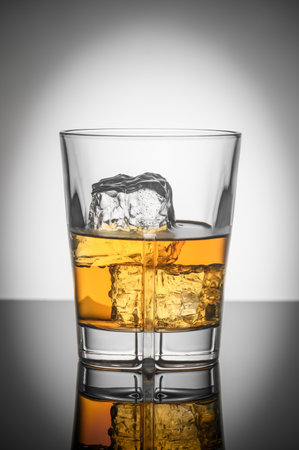 glass of Scotch whiskey with ice on white backgroundの写真素材