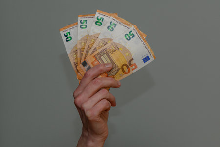 50 euro bills in hand on gray backgroundの写真素材