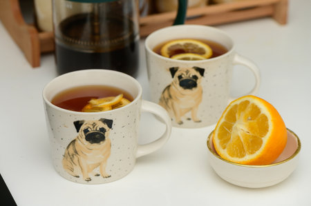 black tea with lemon in cups with a drawn pug 3の写真素材