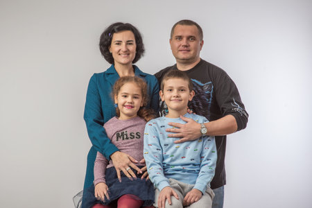 studio portrait of a happy family husband wife daughter and son