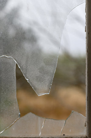 Window with broken glass in old building Wooden window frame with partially broken glass in old...