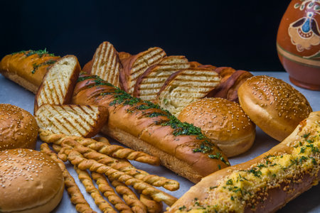 Variety of baked goods on wooden table on black background.の写真素材