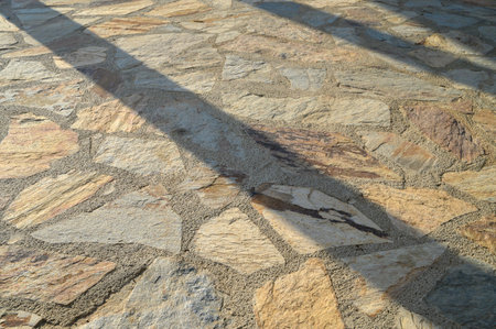 Sun shadow on old stone building wall background