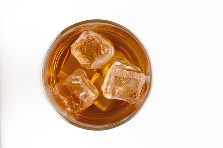 Whiskey served with ice in glasses on a white table top view Area available for textの写真素材