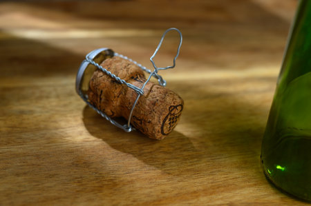 One champagne cork and a ray of light, on a wooden table on a white backgroundの写真素材