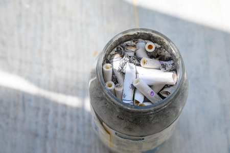 Jar overflowing with cigarette buttsの写真素材