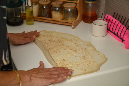 Woman rolling out dough to make bunsの写真素材
