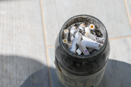Ashtray filled with many cigarette buttsの写真素材