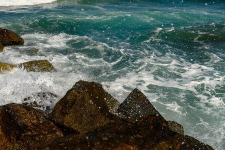 close up beautiful waves of the mediterranean sea breaking on rocks near the shoreの写真素材