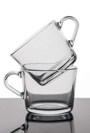transparent tea cups stand one inside another on a white backgroundの写真素材
