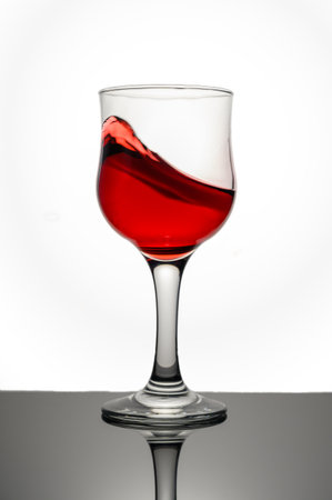 Red wine swirling into glassの写真素材