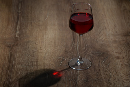 wine in a glass on a wooden tableの写真素材