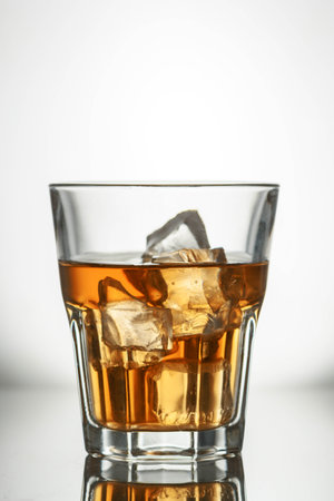 whiskey splashes in a glass on a light background
