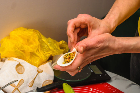 sculpt dumplings by hand with hands in flour. woman holds molded dumplings in her hand.3