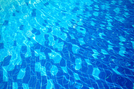 Blue water texture with light reflection. Water surface with rings and ripples, splashes and bubbles