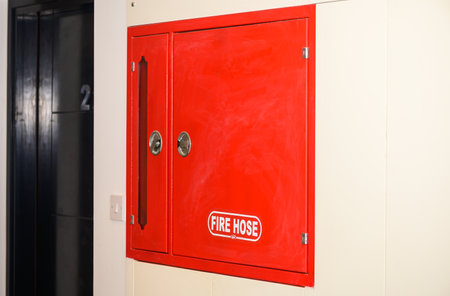 Red fire shield with fire extinguisher in a business center.