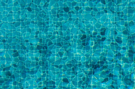 The sunlight dances on the surface of a shimmering pool, creating a tapestry of vibrant blue hues...