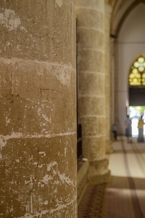 Sunlight streams through stained glass, illuminating weathered stone columns in a timeless cathedral...
