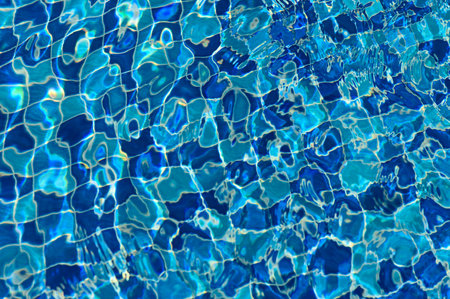 The vibrant reflections create a mesmerizing pattern as water ripples gently under the sun.