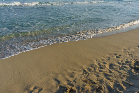Soft waves kiss the golden sand as the sun sets, painting the sky in warm hues of twilight along the...