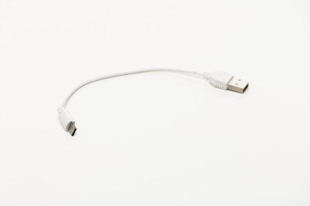 A compact USB cable poised on a clean surface, ready for essential charging and quick data transfer...