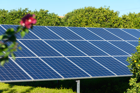 Solar panels glint in the sun, surrounded by vibrant greenery and blooming flowers, exemplifying...