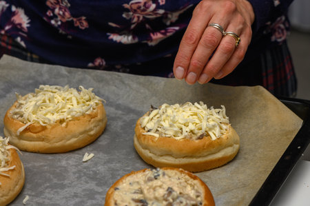 Cheese is artfully sprinkled over warm buns, making a delicious treat perfect for sharing and enjoying.の写真素材