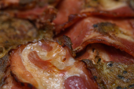 Crispy bacon sizzling on a hot grill, filling the air with mouthwatering aroma at breakfast timeの写真素材