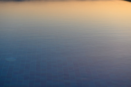 Soft waves undulate gently as warm hues of twilight blend into the calming waters at dusk.