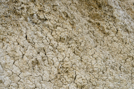 Cracked soil shows the effects of drought, portraying a stark and beautiful texture of nature's...