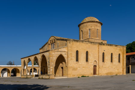 Ancient stones of a beautifully crafted church bask in sunlight, surrounded by quiet village life...