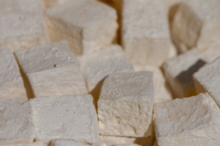 Small, expertly cut cubes of fresh tofu are arranged closely together, showing their smooth texture...