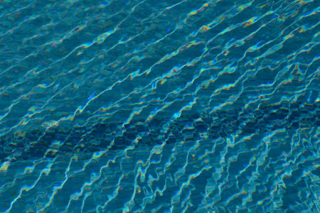 Sunlight glistens on a shimmering pool, creating a mesmerizing pattern of ripples in vibrant shades...