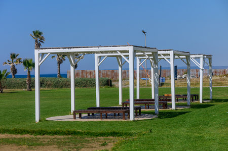 Beach resort scene featuring sunshade canopies with comfortable beach loungers beneath, offering relaxation and shade by the ocean in a tropical paradise.の写真素材