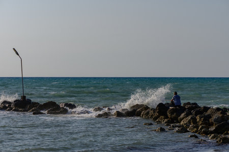 Fisherman on Coastal Rocks Catching Fish in Cyprus by Mediterranean Sea Fisherman on Coastal Rocks...